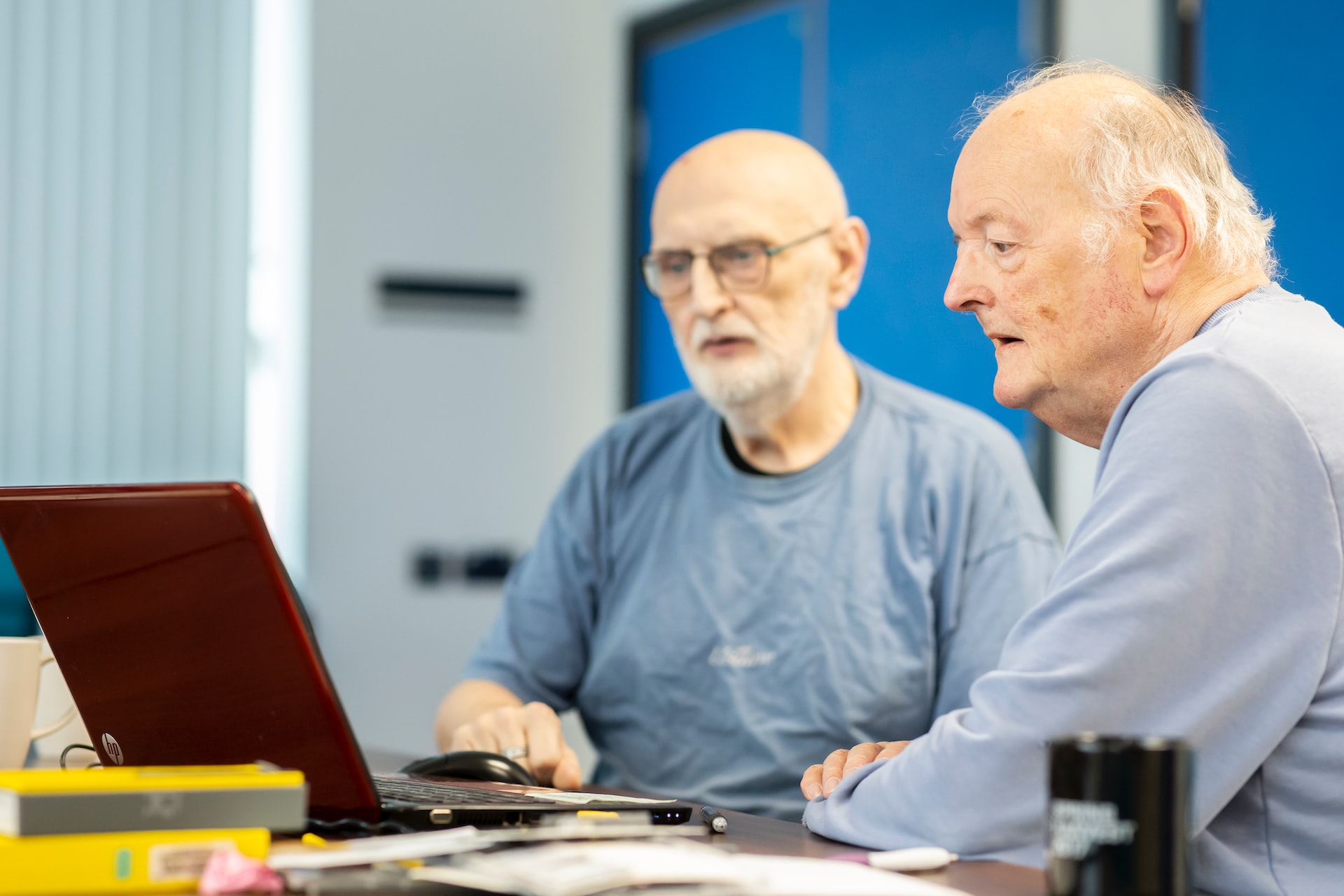 Two elderly men working on a laptop, representing hearsay evidence in estate disputes